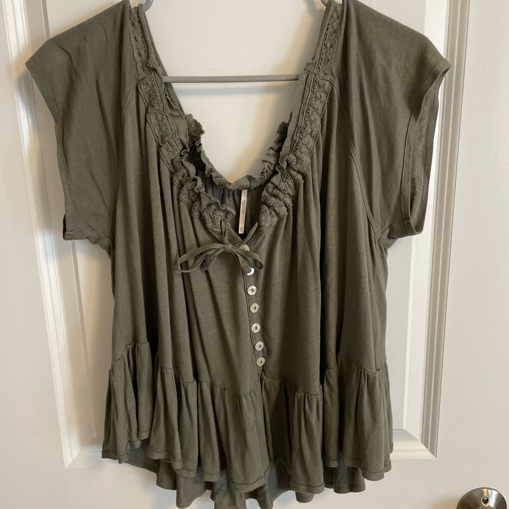 Olive green blouse with ruffle hem and lace details.